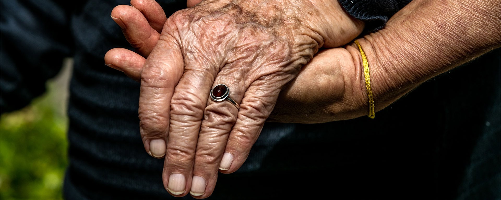 Mitarbeiterin des Hospizvereins hält die Hand einer Patientin